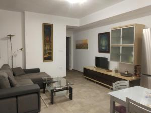 a living room with a couch and a tv at Hierbabuena Rooms in Valencina de la Concepción