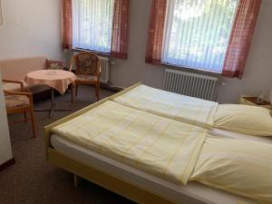 1 dormitorio con 1 cama, mesa y sillas en Gasthaus Glück auf garni, en Häuslingen