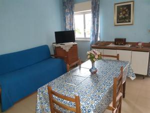 sala de estar con mesa y sofá azul en casa aurora en Calatabiano