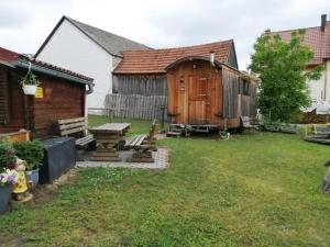 a backyard with a wooden shed and a wooden table at Schäferwagen auf dem Ferienhof Stark in Kelheimwinzer