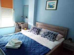 a blue bedroom with a bed with towels on it at Apartment Temple in Podgorica