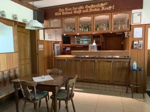 a dining room with a table and a bar at Gasthaus Glück auf garni in Häuslingen