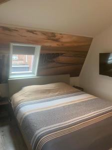 1 cama en un dormitorio con ventana en Brasserie de Peperboom, en Veere