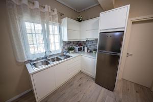 a kitchen with white cabinets and a stainless steel refrigerator at Villa Abiori in Ksamil