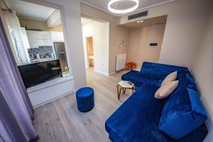 a living room with a blue couch and a television at Villa Abiori in Ksamil