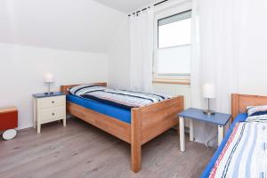a bedroom with two beds and a window at Ferienhaus Nordseeliebe in Esens