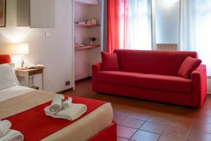 a hotel room with a red couch and a bed at Residence Ferraud in Pinerolo