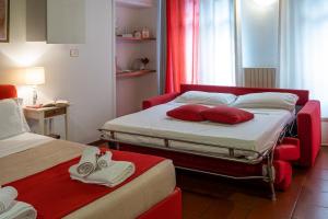 a hotel room with two beds with red pillows at Residence Ferraud in Pinerolo