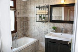 a bathroom with a tub and a sink and a mirror at Traditional Villa Mandola in Kefallonia +39 photos