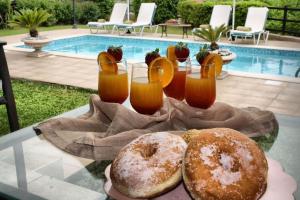 two donuts on a glass table next to a pool at Traditional Villa Mandola in Kefallonia
