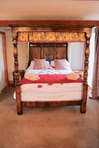 アスクリッグにあるOld Camms Holiday Cottagesのベッドルーム1室(天蓋付きの木製ベッド1台付)