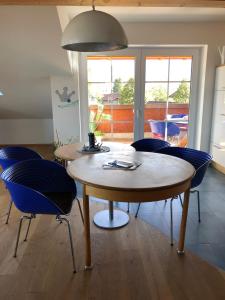 ein Esszimmer mit einem Tisch und blauen Stühlen in der Unterkunft Alpenglück de Luxe Ferienwohnung am Forggensee in Schwangau