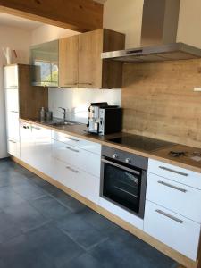 a kitchen with white cabinets and a stove top oven at Alpenglück de Luxe Ferienwohnung am Forggensee in Schwangau