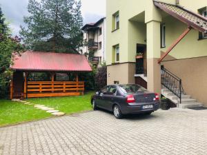 a car parked in a driveway next to a building at Pensjonat Makuch in Korbielów