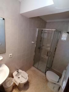 uma casa de banho com um chuveiro, um WC e um lavatório. em Saturno em Cala Millor