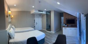 a hotel room with two beds and a television at White Golden Suite Hotel in Trabzon