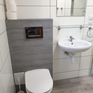 a bathroom with a white toilet and a sink at Pensjonat na Zaciszu in Kąty Rybackie