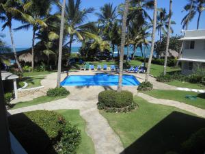 a swimming pool with palm trees and a resort at La Punta Apartamentos in Cabarete