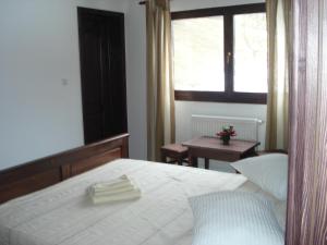 1 dormitorio con cama, ventana y mesa en Cabana Perla, en Cugir