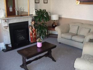 a living room with a couch and a fireplace at The Denewood in Sandown