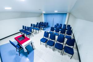 a conference room with blue chairs and a red table at Brasilia Park Hotel in Brasilia