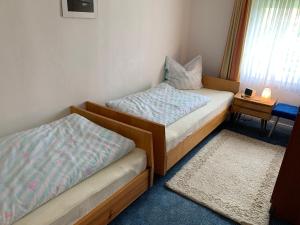 2 camas en una habitación con mesa y ventana en Ferienwohnung Bünger, en Essel