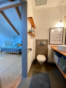 a bathroom with a toilet and a balcony with a bed at Ferienwohnung Röthenbach in Oberaudorf