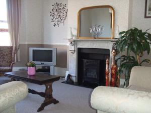 a living room with a fireplace and a television at The Denewood in Sandown