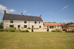 a large white house with a large yard at Jex Farmhouse B&B in Little Snoring
