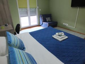 a bedroom with a large bed with a blue blanket at Apartment Temple in Podgorica