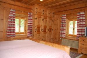 1 dormitorio con 1 cama en una cabaña de madera en Chasa Städler - Ferienwohnung mit 113m2 für max. 5 Personen en Zernez