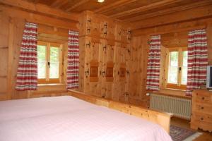 a bedroom with a bed in a log cabin at Chasa Städler - Ferienwohnung mit 113m2 für max. 5 Personen in Zernez