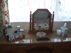a dresser with a mirror on top of a table at The Denewood in Sandown