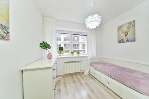 a white room with a bed and a desk at Apartament Karpatka in Karpacz