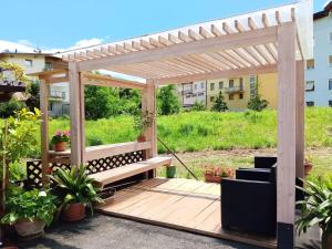 een houten pergola met een bank op een terras bij Loft Monte Peller in Cles