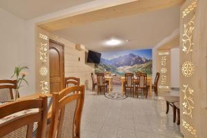 a dining room with chairs and a painting on the wall at Agroturystyka Pokoje na Zakręcie in Białka Tatrzanska