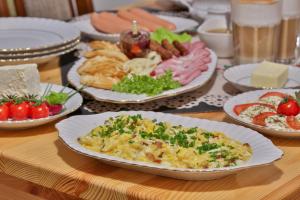 a table with plates of food on a table at Pokoje na Zakręcie - Blisko term bania oraz restauracji - Rodzinna Atmosfera in Białka Tatrzańska