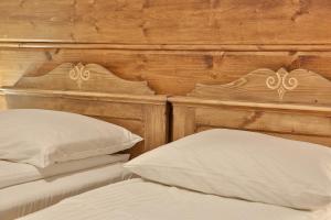 two beds with white pillows and a wooden headboard at Agroturystyka Pokoje na Zakręcie in Białka Tatrzanska