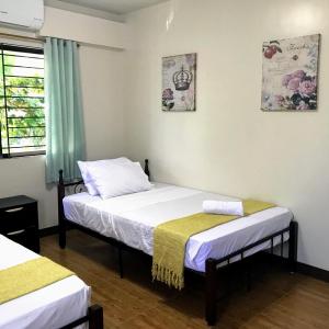 1 dormitorio con 2 camas y ventana en Sajo Plaza & Residences, en Iloilo City