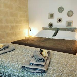 1 Schlafzimmer mit 2 Betten mit Handtüchern und Blumen auf dem Bett in der Unterkunft Trulli di nonna Palma in Locorotondo