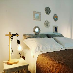 ロコロトンドにあるTrulli di nonna Palmaのベッドルーム1室(ランプと壁に鏡が付いたベッド1台付)