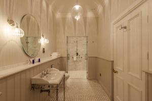 a bathroom with a sink, mirror, and bathtub at Cahernane House Hotel in Killarney