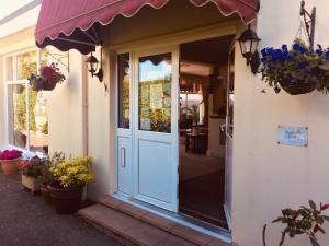 Una porta di un edificio con dei fiori sopra di Seawold Guest House a St Brelade