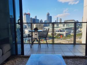 a balcony with a table and a view of a city at Harbour Escape Apartments Docklands in Melbourne