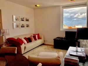 a living room with a couch and a large window at Lisbon Chiado One in Lisbon
