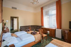 City Hotel UNIO superior في بودابست: غرفة نوم بسريرين وطاولة واريكة