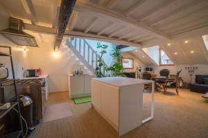 een keuken en een woonkamer met een trap bij Appartements atypiques centre ville Annecy in Annecy