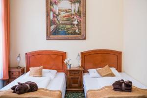 a bedroom with two beds and a picture on the wall at City Hotel UNIO superior in Budapest