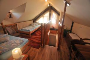 a attic room with two beds and a window at Soludus-Spišský ľudový dom in Smižany