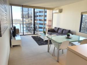 a living room with a couch and a table at Harbour Escape Apartments Docklands in Melbourne